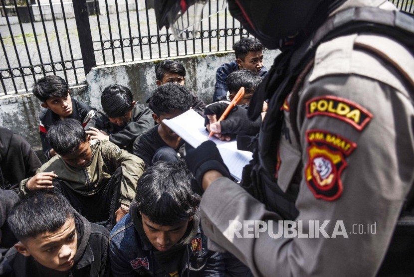 Petugas Kepolisian mendata oknum perusuh pada peringatan Hari Buruh (May Day) di kawasan Jalan Layang Pasupati, Kota Bandung, Rabu (1/5). 