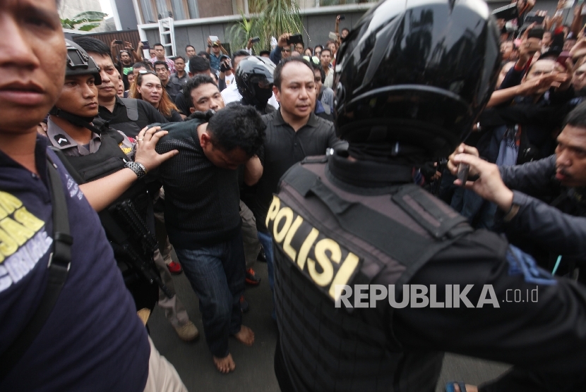Petugas kepolisian mengamankan salah satu pelaku perampokan dan penyanderaan di salah satu rumah kawasan Pondok Indah, Jakarta, Sabtu (3/9).