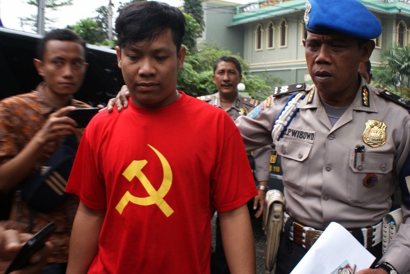 Petugas kepolisian mengamankan seorang pemuda yang kedapatan mengenakan kaos bergambar Palu Arit yang menjadi lambang Partai Komunis Indonesia di Ciputat, Tangerang Selatan, Banten, Jumat (27/5). 
