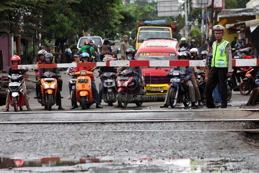 Petugas kepolisian mengatur lalu lintas di Pintu Perlintasan KA Pesanggerahan ketika diberlakukan sistem satu arah, Bintaro, Jakarta Selatan, Senin (23/12).  (Republika/Yasin Habibi)