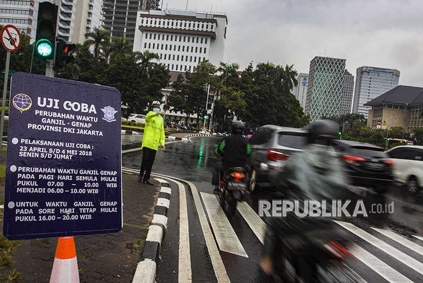 Petugas Kepolisian mengatur lalu lintas saat sistem ganjil genap di Jalan Medan Merdeka Barat, Jakarta
