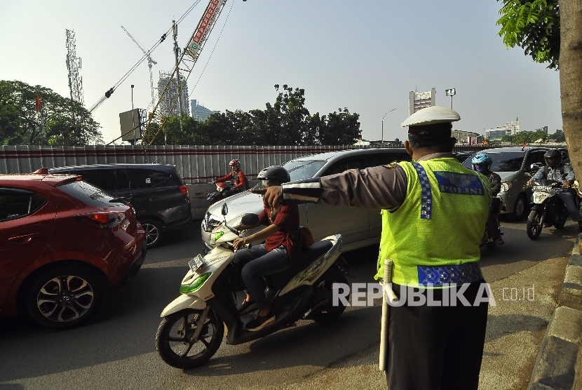 Petugas kepolisian mengatur rekayasa lalu lintas di Jalan Mampang, Jakarta Selatan, Senin (24/7).