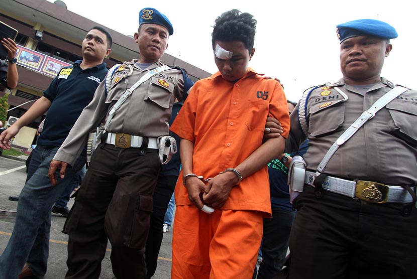 Petugas kepolisian mengawal seorang tersangka kasus pembunuhan Roy Mando Sah Siregar (20) saat gelar kasus di Mapolresta Medan, Sumatera Utara, Selasa (3/5). 
