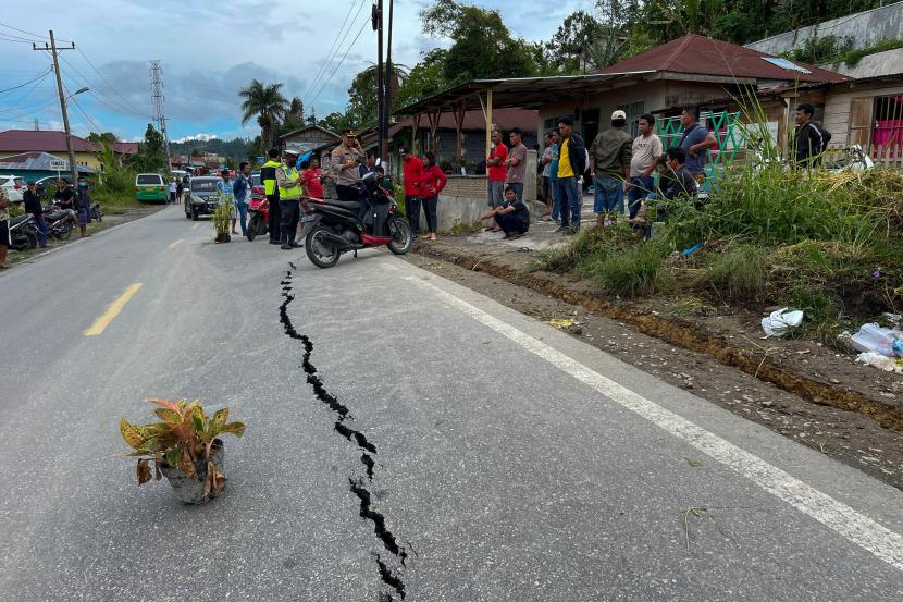 Petugas kepolisian mengecek kondisi sejumlah rumah warga yang rusak akibat gempa yang terjadi di kawasan Pahae Jae, Tapanuli Utara, Sumatra Utara, Sabtu (1/10/2022). Gempa bumi berkekuatan 6.0 SR yang mengguncang wilayah Tapanuli Utara tersebut terjadi sekitar pukul 02.28 dan mengakibatkan satu orang meninggal dunia serta 11 orang luka-luka. 