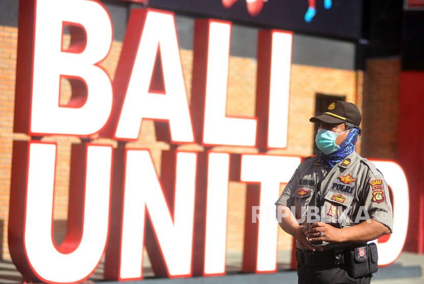 Petugas kepolisian mengenakan masker saat melakukan penjagaan pertandingan Liga 1 2020 antara Bali United melawan Madura United di Stadion Kapten I Wayan Dipta, Gianyar, Bali, Ahad (15/3/2020).