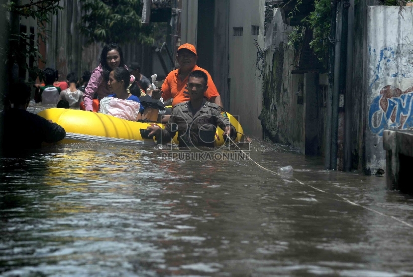Petugas kepolisian menggunakan perahu karet mengevakuasi warga yang rumahnya terendam banjir di Petogogan, Jakarta Selatan, Selasa (10/2).(Republika/Agung Supriyanto)