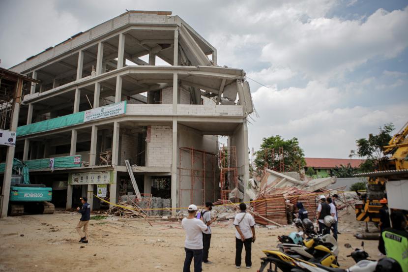Petugas kepolisian mengunjungi lokasi bangunan SMAN 96 Jakarta yang roboh di Jakarta, Kamis (18/11/2021). Gedung SMAN 96 Jakarta yang masih dalam proses pembangunan tersebut roboh pada Rabu (17/11) siang dan mengakibatkan empat orang pekerja proyek mengalami luka-luka.