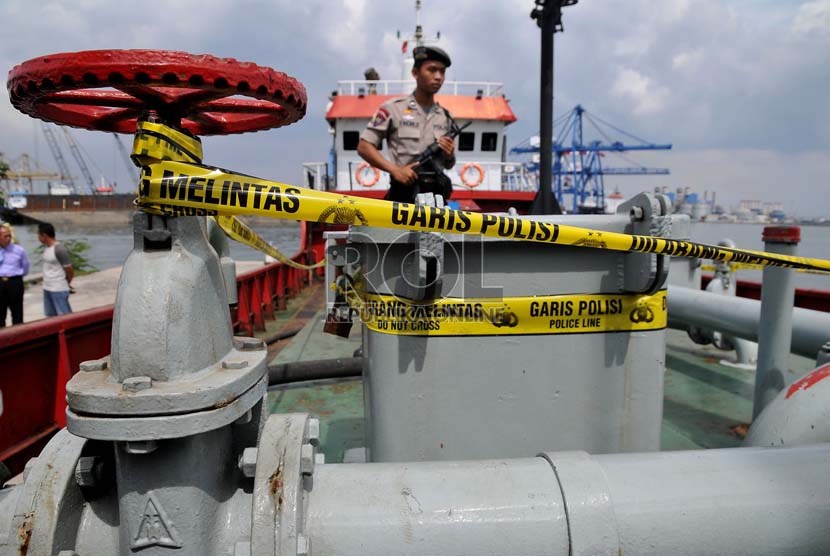  Petugas kepolisian menjaga kapal tangker KM Kuda Laut 88 yang membawa bahan bakar minyak (BBM) selundupan di Pulau Pondok Dayung, Jakarta utara, Rabu (19/6).    (Republika/Prayogi)
