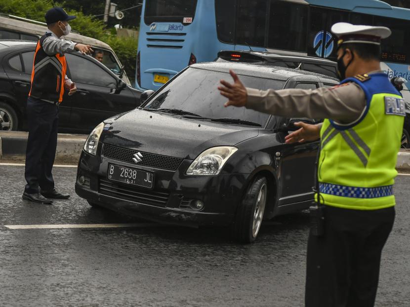 Petugas Kepolisian mensosialisasikan aturan penerapan sistem ganjil-genap kepada pengendara di Jalan Farmawati, Jakarta, Senin (25/10). Direktorat Lalu Lintas Polda Metro Jaya memperluas penerapan aturan pembatasan lalu lintas ganjil-genap di 13 ruas Jalan di Jakarta.