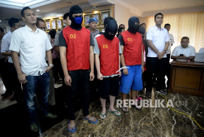 Petugas kepolisian menunjukan barang bukti dan tersangka saat rilis kasus tindak pidana pornografi melalui Facebook di Mapolda, Jakarta, Selasa (14/3). 