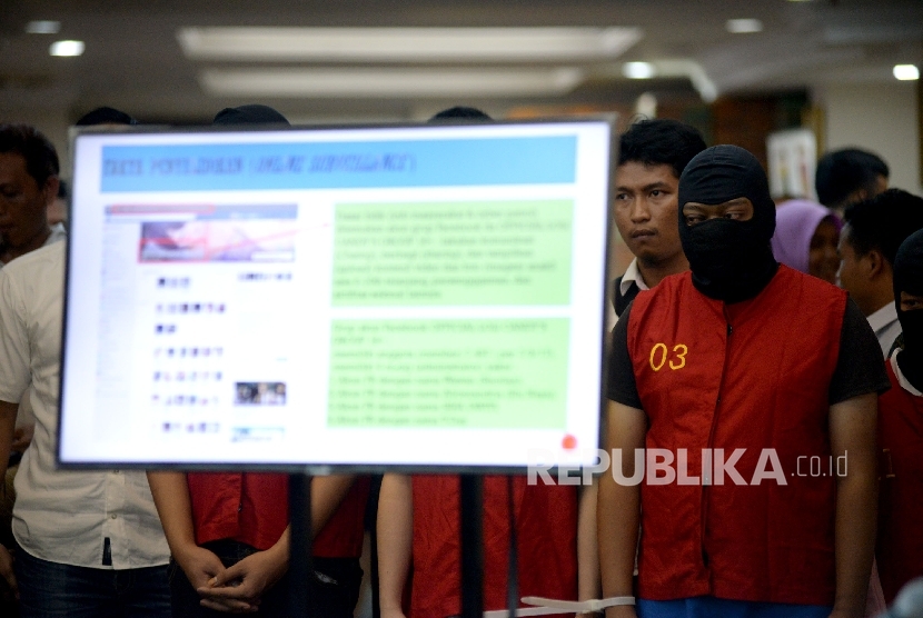 Petugas kepolisian menunjukan barang bukti dan tersangka saat rilis kasus tindak pidana pornografi melalui Facebook di Mapolda, Jakarta, Selasa (14/3).