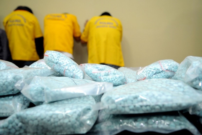  Petugas kepolisian menunjukan tiga orang tersangka beserta barang bukti berupa narkoba jenis shabu dan ecstasy saat jumpa pers di Polres Jakarta Barat, Selasa (19/6). (Prayogi/Republika)