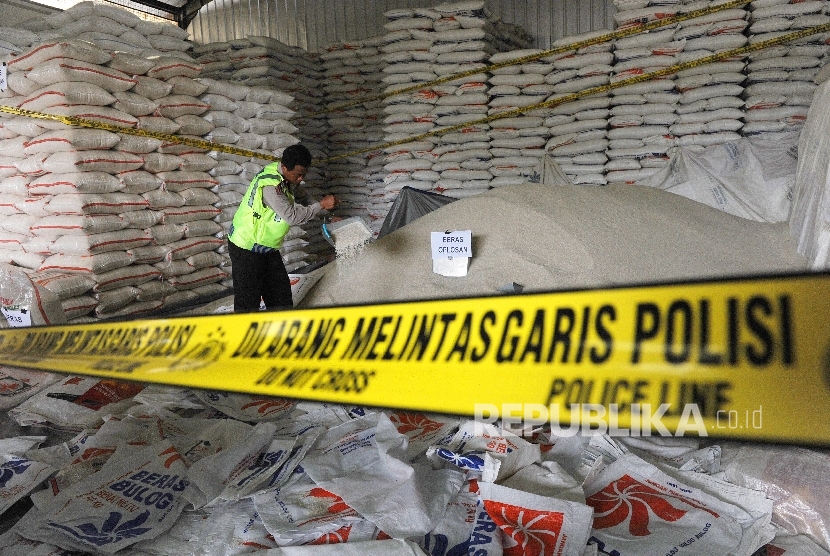 Petugas kepolisian menunjukkan barang bukti beras oplosan di salah satu gudang di Pasar Induk Beras Cipinang, Jakarta, Jumat (7/10). 