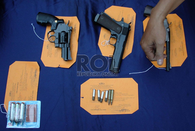  Petugas kepolisian menunjukkan barang bukti dan tersangka pada rilis tindak pidana menyimpan dan kepemilikan senjata api rakitan dan air softgun di Polsek Penjaringan, Jakarta Utara, Senin (26/8). ( Republika/Yasin Habibi)