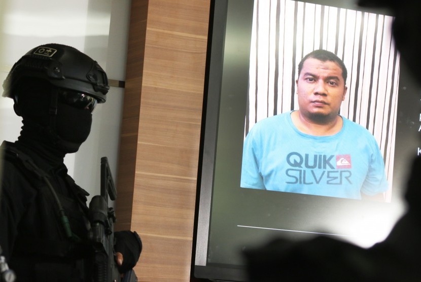 Police officer shows photograph of suspected terrorist during press conference in Jakarta, Thursday (June 22). 