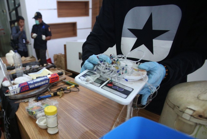 Petugas kepolisian menunjukkan sejumlah barang bukti yang diamankan saat penangkapan para terduga teroris yang berada di Bekasi, di Mabes Polri, Jakarta, Kamis (15/12).