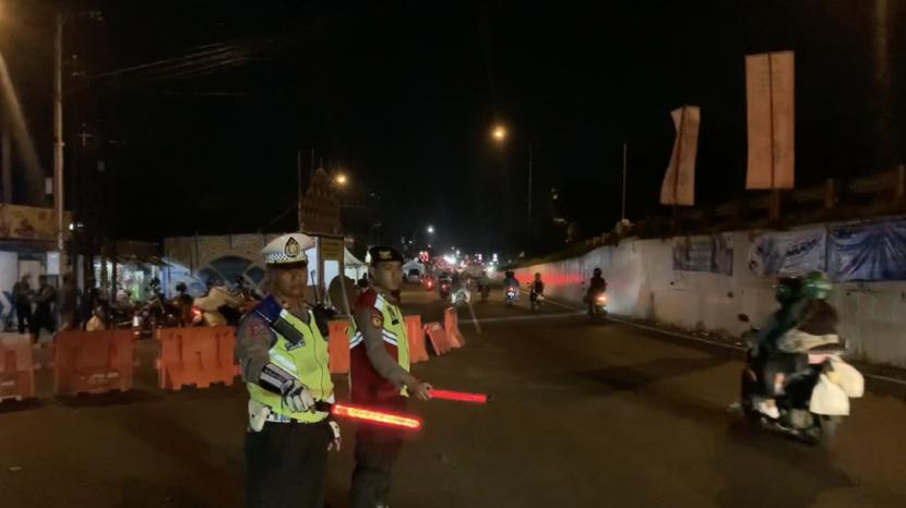 Personel Polres Karawang melakukan pengaturan lalu lintas di Simpang Jomin, Karawang, Jawa Barat, Selasa (25/4/2023) malam.