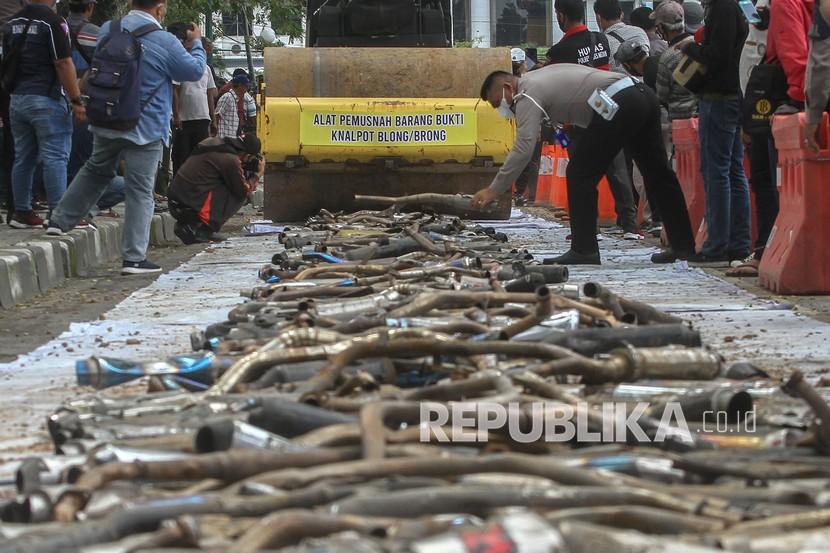 Petugas Kepolisian Satlantas Polrestabes Medan menggunakan alat berat disaat memusnahkan barang bukti tangkapan knalpot blong (bising) di Medan, Sumatra Utara, beberapa waktu lalu.