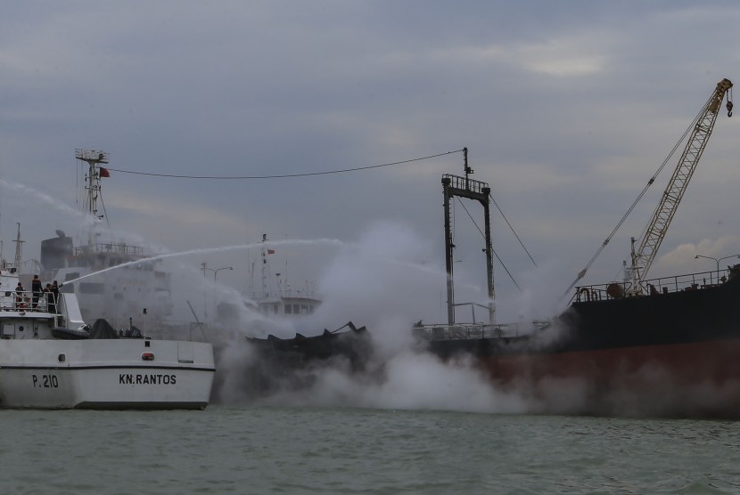Petugas Kesatuan Penjaga Laut dan Pantai (KPLP) dengan KN Rantos menyemprotkan air ke arah kapal tanker yang terbakar di pelabuhan rakyat, Batu Ampar, Batam, Kepulauan Riau, Rabu (16/11). 