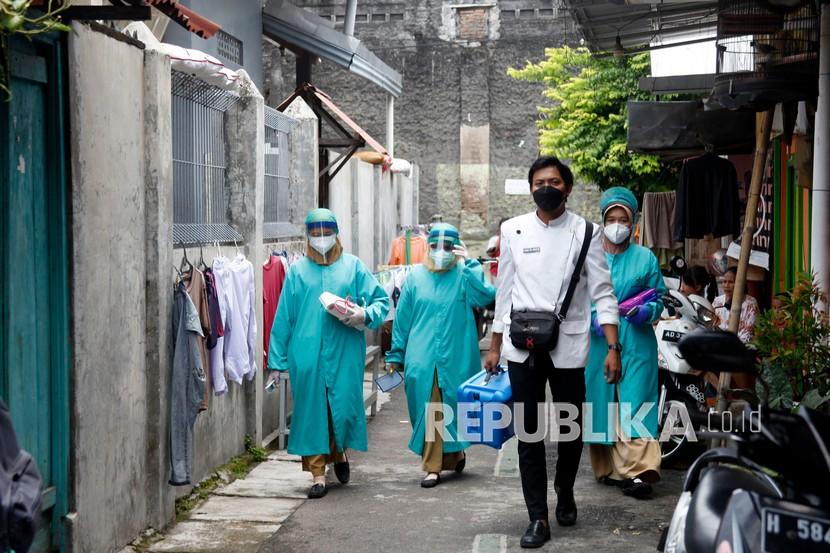 Petugas kesehatan berjalan menuju rumah warga untuk melakukan vaksinasi COVID-19 di Sondakan, Laweyan, Solo, Jawa Tengah, Kamis (4/11/2021). Jemput bola vaksinasi untuk warga tersebut sebagai upaya percepatan Vaksinasi COVID-19. 