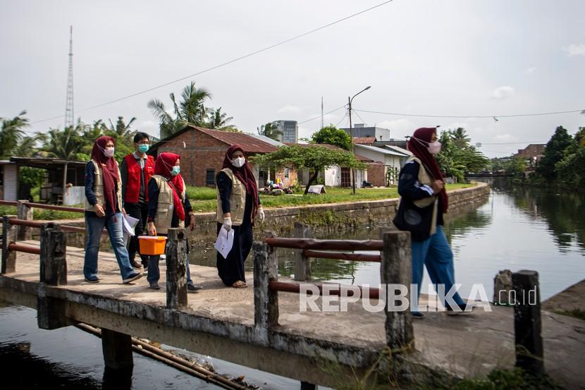 Petugas kesehatan dari Puskesmas Kampus Palembang berjalan menuju rumah warga penerima vaksin COVID-19 dari pintu ke pintu (door to door) di Palembang, Sumatera Selatan, Sabtu (15/1/2022). Kasus konfirmasi aktif COVID-19 di Kota Palembang, Sumatera Selatan, didominasi oleh para pelaku perjalanan ke luar kota