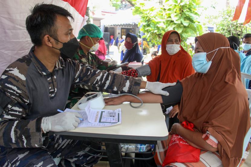 Petugas kesehatan dari Sekolah Tinggi Teknologi Angkatan Laut (STTAL) memeriksa kesehatan seorang warga saat vaksinasi COVID-19 di Posko PPKM Mikro Taman Pondok Jati, Geluran, Sidoarjo, Jawa Timur, Kamis (16/9/2021). STTAL melakukan serbuan vaksinasi untuk mendukung kebijakan pemerintah yang menargetkan capaian pemberian 2,3 juta suntikan dosis vaksin COVID-19 per hari dan mempercepat tercapainya kekebalan kelompok (herd immunity).