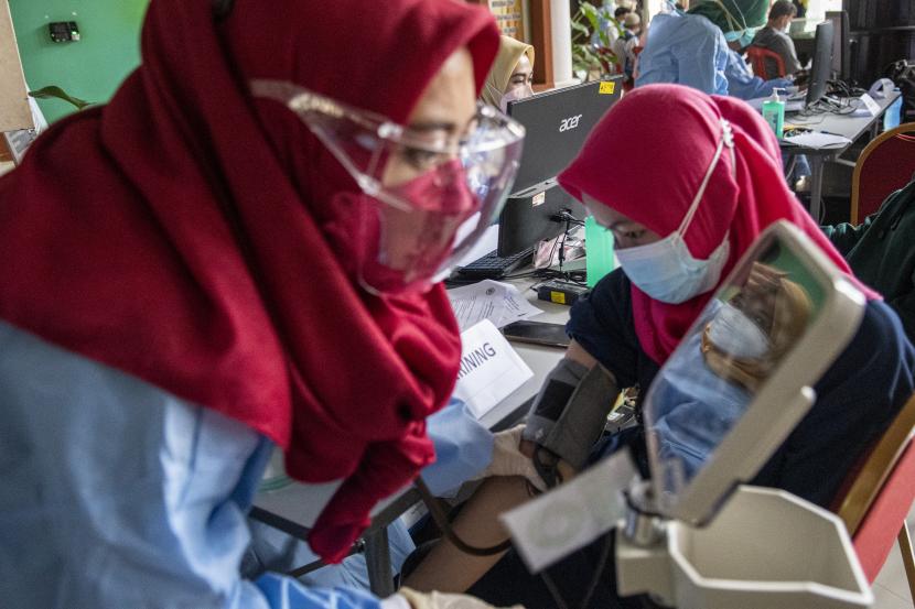 Petugas kesehatan melakukan pemeriksaan awal kepada anak usia 12-18 tahun yang akan menjalani vaksinasi COVID-19 di RSUP Dr Mohammad Hoesin Palembang, Sumatera Selatan, Sabtu (10/7/2021). Dalam rangka Hari Anak Nasional, Dinas Kesehatan kota Palembang bekerja sama dengan Ikatan Dokter Anak Indonesia (IDAI) dan RSUP Dr Mohammad Hoesin Palembang menggelar vaksinasi massal COVID-19 terhadap anak usia 12-18 tahun dengan target 1.000 orang anak per hari.