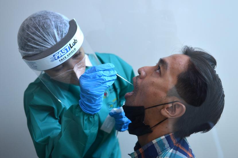 Petugas kesehatan melakukan pengambilan sampel untuk pemeriksaan RT-PCR saat simulasi penerbangan internasional di Bandara Internasional I Gusti Ngurah Rai, Badung, Bali, (ilustrasi).