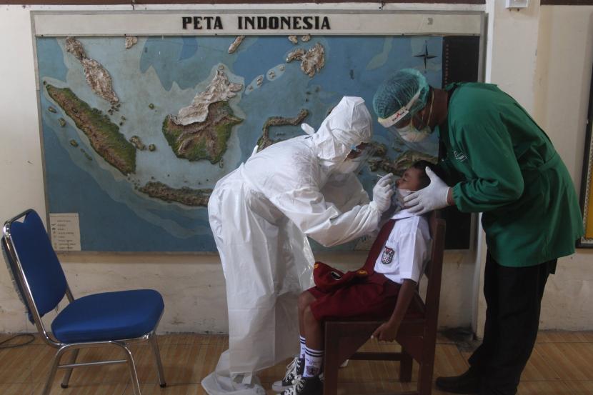 Petugas kesehatan melakukan tes usap antigen kepada siswa di SDN 40 Laweyan Solo, Jawa Tengah, Senin (27/9/2021). Tes usap yang diikuti 117 siswa dan belasan guru sekolah setempat dilakukan usai orang tua murid memberikan laporan bahwa ada beberapa guru setempat yang tidak memakai masker saat pembelajaran tatap muka (PTM).