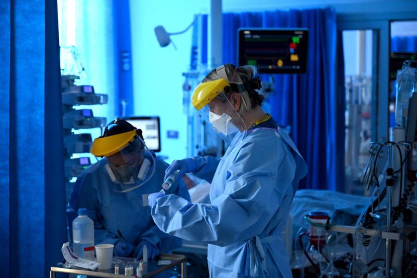  Petugas kesehatan memakai Alat Pelindung Diri (APD) saat merawat pasien di unit Perawatan Intensif di Rumah Sakit Royal Papworth di Cambridge, Inggris 
