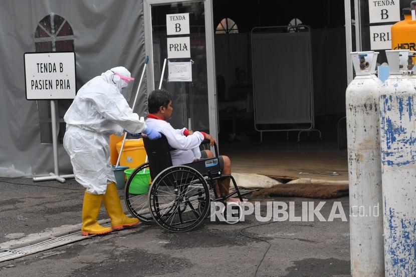 Petugas kesehatan membantu seorang pasien COVID-19 memasuki ruangan di Rumah Sakit Lapangan Kogabwilhan II Jalan Indrapura, Surabaya, Jawa Timur, Selasa (12/1/2021). Berdasarkan data Satuan Tugas Penanganan COVID-19 pada Selasa (12/1) kasus positif COVID-19 bertambah 10.047 orang menjadi 846.765 orang, sementara kasus pasien sembuh bertambah 7.068 orang menjadi 695.645 orang. 
