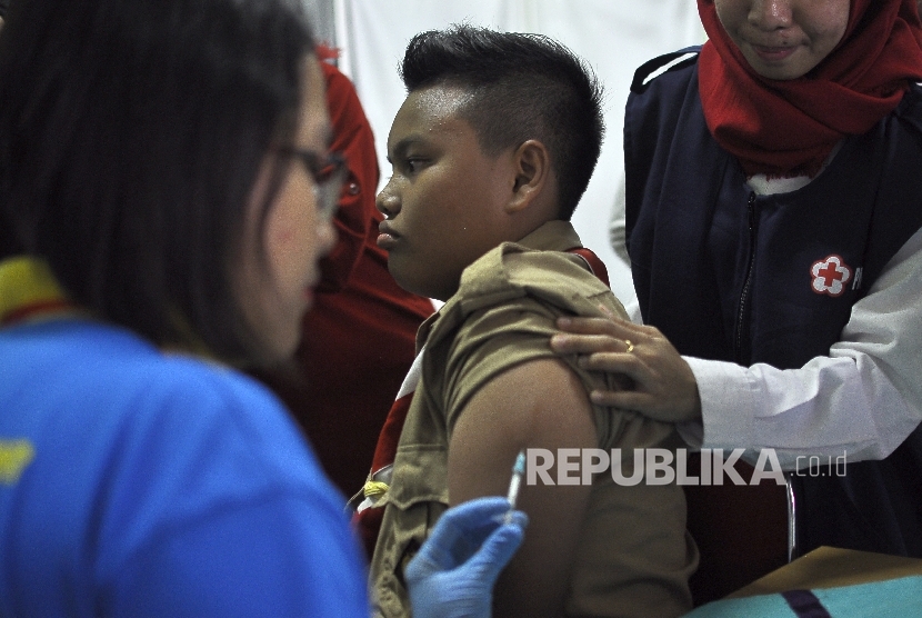 Petugas kesehatan memberikan suntikan imunisasi Measleas Rubela (MR) kepada sejumlah siswa-siswi saat acara Kampanye Measles Rubella (MR) dan Campak sekaligus Peringati Asean Dengeu Day 2017 di SMPN 103 Cijantung, Jakarta, Rabu (2/7).