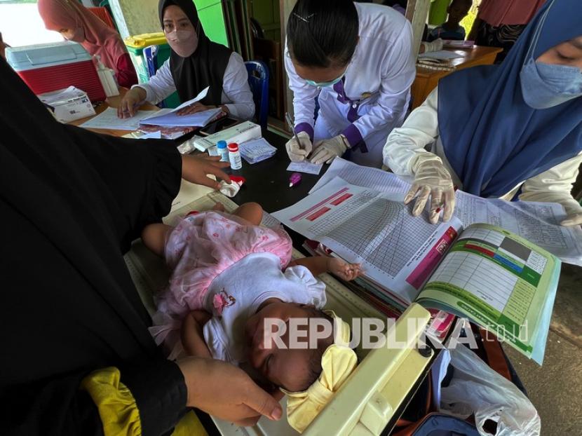 Petugas kesehatan memeriksa bayi saat imunisasi di salah satu posyandu (ilustrasi). Dinas Kesehatan Kota Jayapura, Papua, berharap semua anak di wilayah itu bisa mendapatkan imunisasi dasar lengkap.