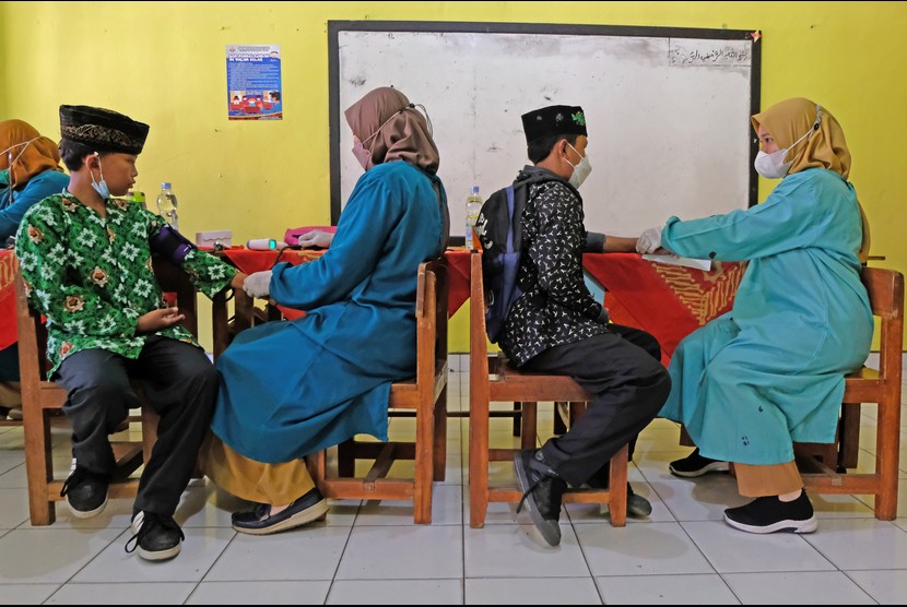 Petugas kesehatan memeriksa kesehatan murid saat vaksinasi COVID-19 bagi pelajar di SD Negeri Krincing, Secang, Magelang, Jawa Tengah, Selasa (4/1/2022). Vaksinasi COVID-19 bagi anak umur 6-11 tahun tersebut bertujuan mempercepat dan memperluas pelaksanaan PTM (Pembelajaran Tatap Muka) di seluruh wilayah Indonesia. 