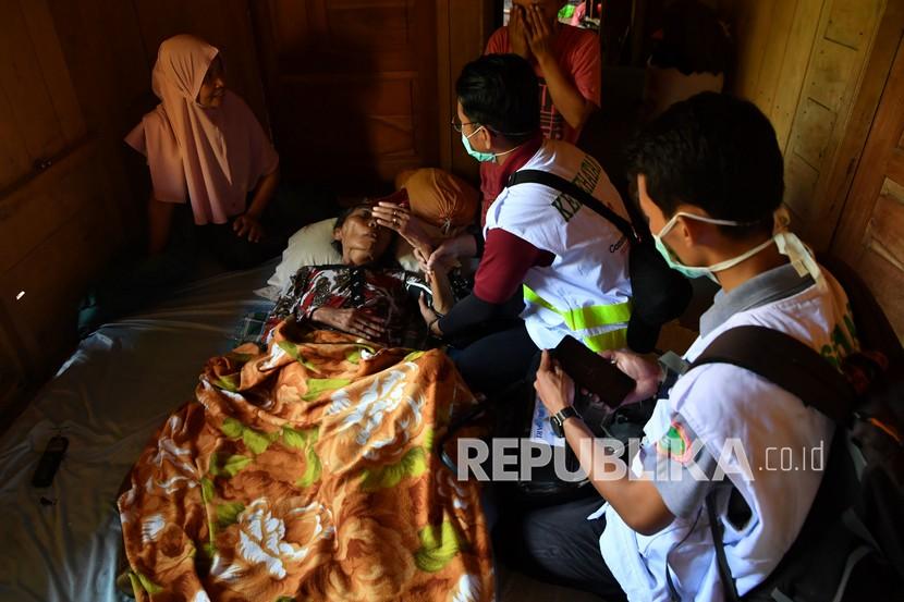 Petugas kesehatan memeriksa kondisi salah satu warga lansia yang sakit di Desa Kaliuling, Lumajang, Jawa Timur, Senin (12/4/2021). Tidak adanya posko kesehatan yang dibangun di lokasi bencana menyebabkan tim kesehatan mengunjungi warga yang sakit di rumah atau pun tenda darurat yang dibangun di sekitar rumah mereka yang rusak. 