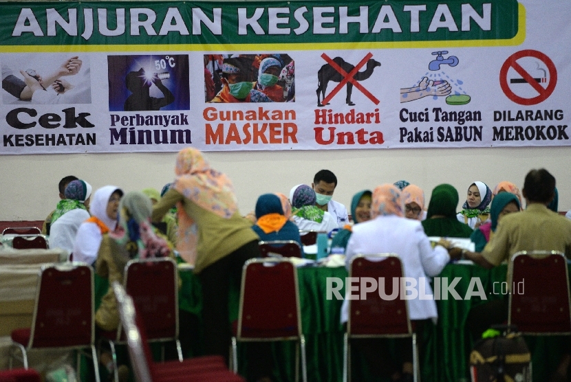  Petugas kesehatan memeriksa riwayat kesehatan jamaah calon haji Kloter 25 di Embarkasi DKI Jakarta, Pondok Gede, Jakarta, Selasa (8/8)