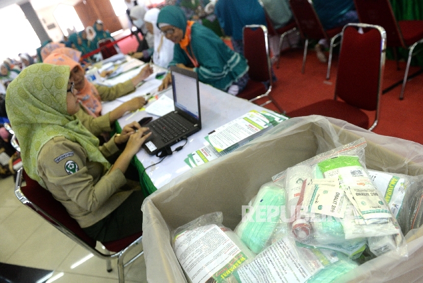 Petugas kesehatan memeriksa riwayat kesehatan jamaah calon haji Kloter 25 di Embarkasi DKI Jakarta, Pondok Gede, Jakarta, Selasa (8/8).