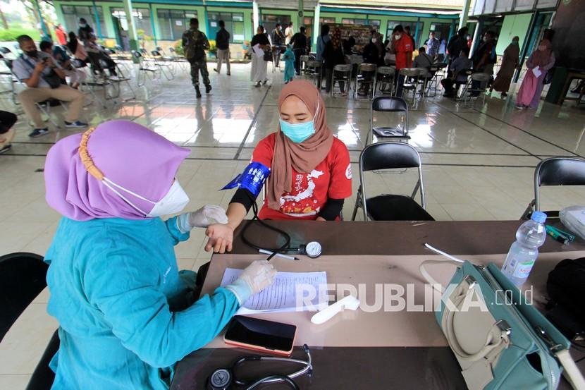 Petugas kesehatan memeriksa warga sebelum disuntik vaksin COVID-19 saat vaksinasi massal Markas Kodim 0616 Indramayu, Jawa Barat, Kamis (24/6/2021). Vaksinasi massal tersebut ditujukan untuk keluarga tentara, mahasiswa dan masyarakat umum guna percepatan vaksinasi di Indramayu. 