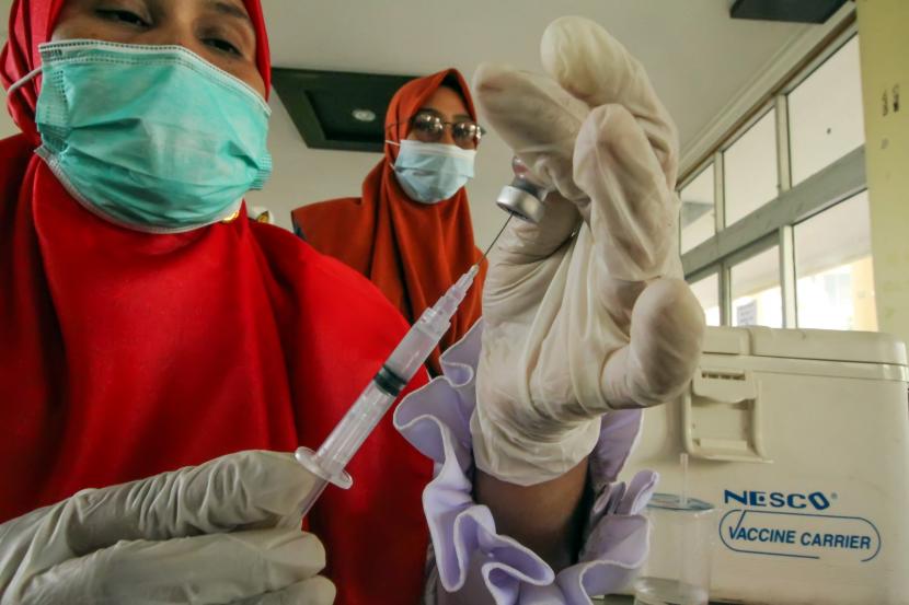 Petugas kesehatan mempersiapkan vaksin COVID-19 yang akan disuntikkan pada mahasiswa di Kampus Politeknik Negeri Lhokseumawe, Aceh, Selasa (14/9/2021). Vaksinasi bagi mahasiswa dan pegawai kampus kerja sama Dinas Kesehatan, TNI, Polri itu untuk meningkatkan kekebalan tubuh sekaligus mempercepat program vaksinasi nasional dalam rangka penanggulangan pandemi COVID-19.