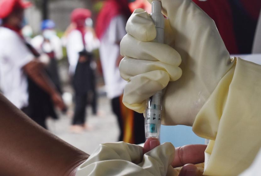 Petugas kesehatan mengambil sampel darah pekerja saat tes diagnostik cepat (rapid test) COVID-19 di sebuah pabrik rokok di Kabupaten Madiun, Jawa Timur, Rabu (27/5/2020). Rapid test yang dilakukan terhadap 890 pekerja di pabrik rokok tersebut dimaksudkan untuk mencegah penyebaran COVID-19 menyusul ditemukannya seorang pekerja terkonfirmasi positif COVID-19 di pabrik rokok tersebut. 
