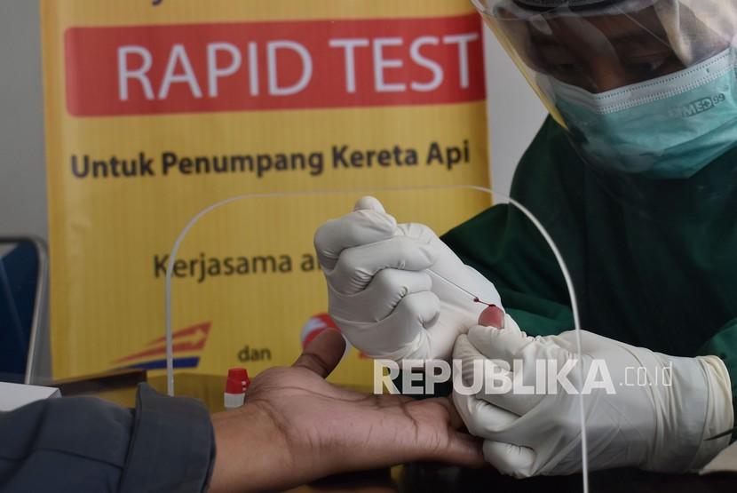 Petugas kesehatan mengambil sampel darah saat tes diagnostik cepat (rapid test) COVID-19 pada calon penumpang Kereta Api (KA) di Stasiun KA Madiun, Jawa Timur, Kamis (30/7/2020). PT KAI (Persero) bersinergi dengan PT Rajawali Nusantara Indonesia (Persero) yang keduanya merupakan BUMN yakni dengan menyediakan layanan rapid test COVID-19 dengan tarif Rp85 ribu pada penumpang KA.