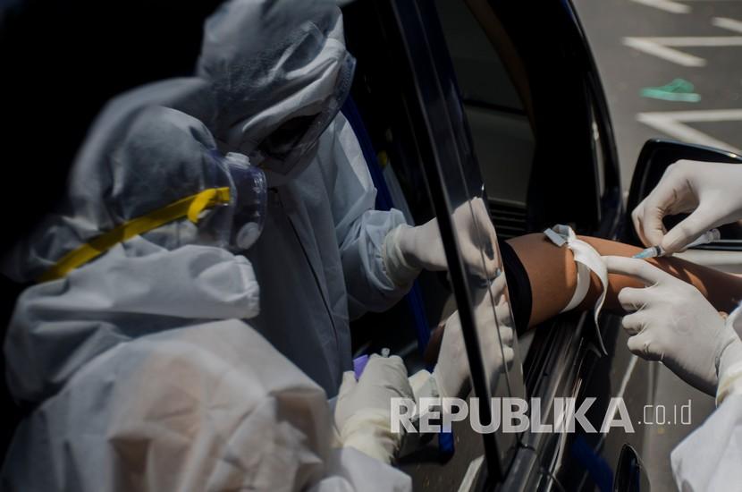 Petugas kesehatan mengambil sampel darah warga saat Rapid Test COVID-19 secara Drive-Thru di Taman Balai Kota Bandung, Jawa Barat, Sabtu (4/4/2020). Pemprov juga segera akan mengirimkan alat rapid test ke Pangandaran.