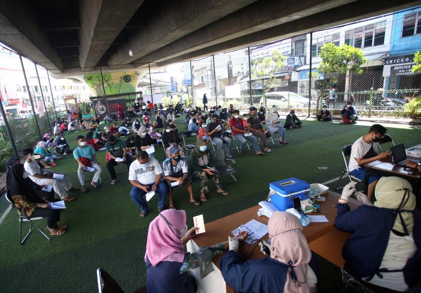 Petugas kesehatan mengecek kesehatan warga yang akan mengikuti vaksin booster COVID-19 di bawah jembatan layang Ciputat, Tangerang Selatan, Banten, Sabtu (2/4/2022). Vaksinasi yang diselenggarakan Polri diikuti warga sekitar dan pedagang Ciputat yang berencana akan mudik lebaran.
