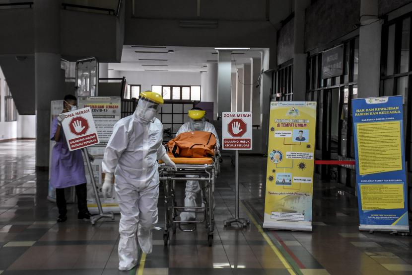 Petugas kesehatan menggunakan alat pelindung diri (APD) membawa jenazah dengan protokol Covid-19 di ruang Instalasi Gawat Darurat (IGD) Rumah Sakit Dokter Hasan Sadikin (RSHS), Kota Bandung.