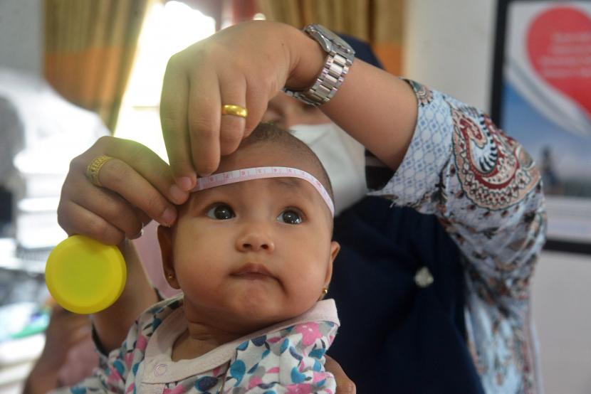 Petugas kesehatan mengukur lingkar kepala anak balita pada kegiatan imunisasi (ilustrasi)