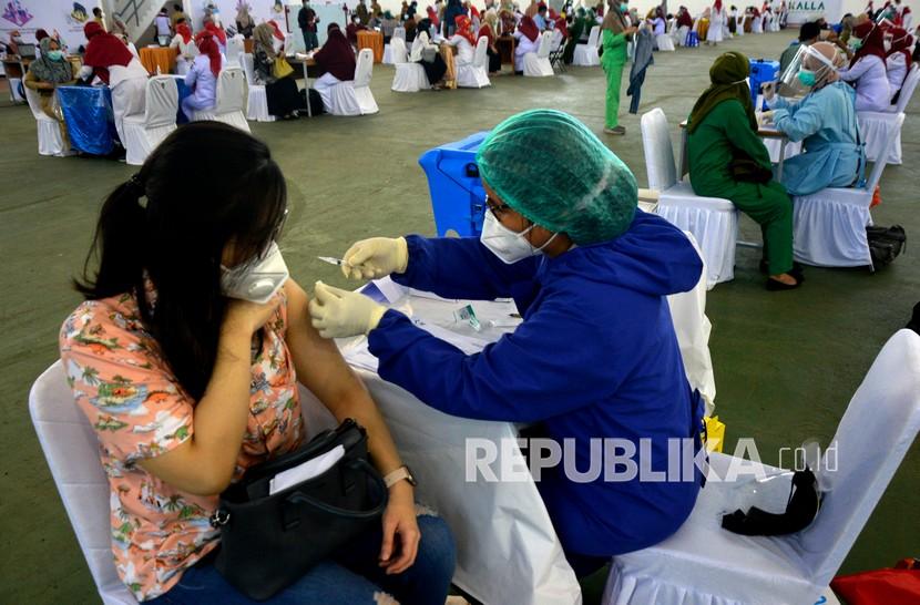 Petugas kesehatan menyuntikan dosis pertama vaksin COVID-19 Sinovac ke seorang tenaga kesehatan di kampus Universitas Hasanuddin (Unhas) Makassar, Sulawesi Selatan, Senin (1/2/2021). Vaksin massal tersebut menargetkan sebanyak 4.000 tenaga kesehatan yang bertugas di fasilitas kesehatan pemerintah dan swasta se-kota Makassar untuk menerima dosis pertama vaksin. 