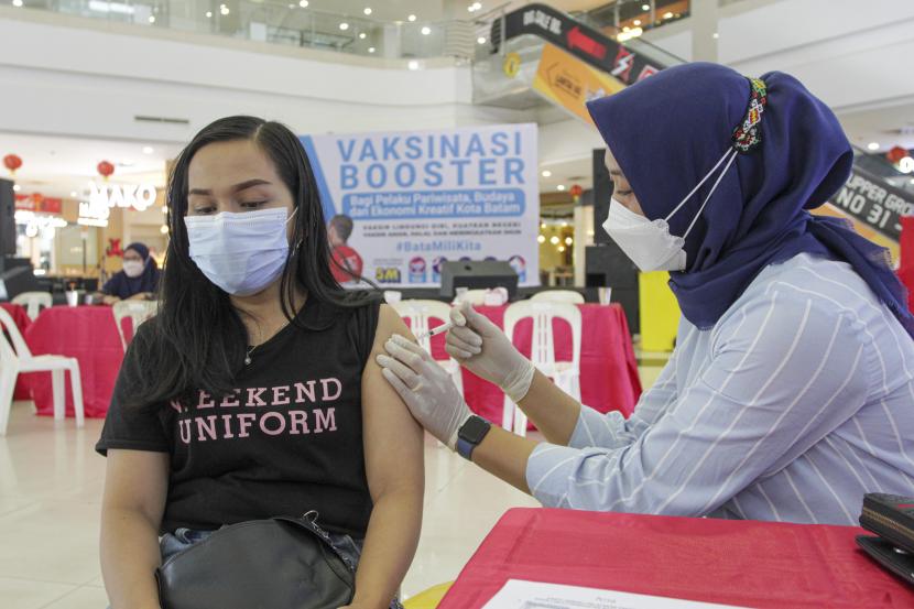 Petugas kesehatan menyuntikan vaksin COVID-19 dosis ketiga atau booster kepada seorang pelaku pariwisata di Batam , Kepulauan Riau, kamis (27/1/2022). Penerima vaksin dosis kedua di Indonesia kini telah mencapai jumlah 126.413.464 orang.
