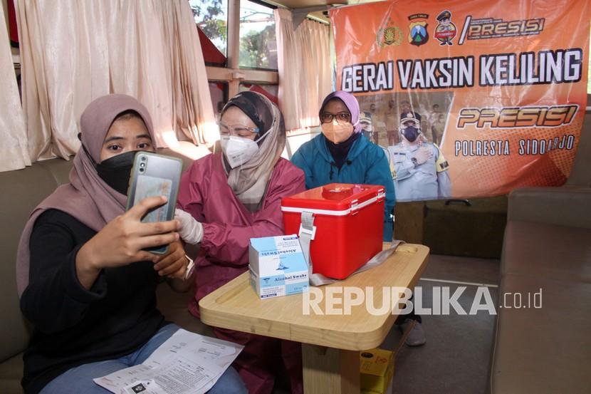 Petugas kesehatan menyuntikan vaksin COVID-19 kepada warga di dalam bus Gerai Vaksin Mobile di Sidoarjo, Jawa Timur, Jumat (13/8/2021). Layanan bus Gerai Vaksin Mobile Presisi tersebut untuk melakukan vaksinasi COVID-19 kepada warga guna mewujudkan kekebalan kelompok atau 