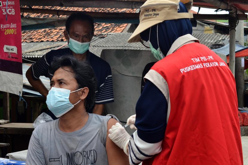 Petugas kesehatan menyuntikan vaksin Pfizer kepada warga saat melakukan kegiatan vaksinasi door to door (DTD).