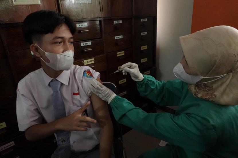 Petugas kesehatan menyuntikkan vaksin Covid-19 dosis ketiga (booster) kepada seorang siswa di SMK N 2 Purwokerto, Banyumas, Jateng, Senin (18/7/2022). Demi meningkatkan cakupan vaksinasi booster, komunitas pendidikan dapat diwajibkan untuk mendapatkannya sebagai syarat mengikuti pembelajaran tatap muka (PTM).